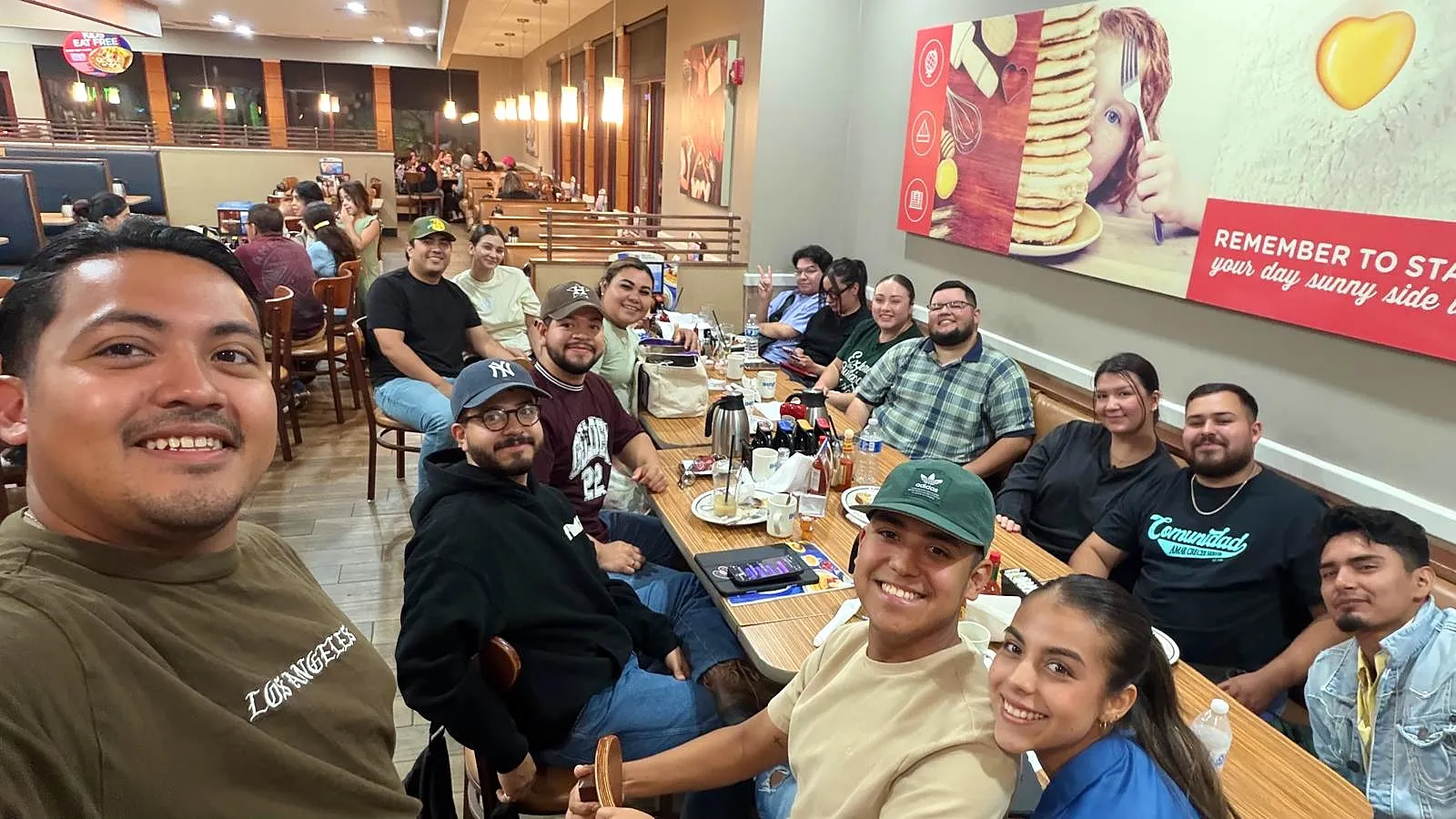 Hermanos de Camino Church sonriendo alrededor de una mesa después de un estudio bíblico