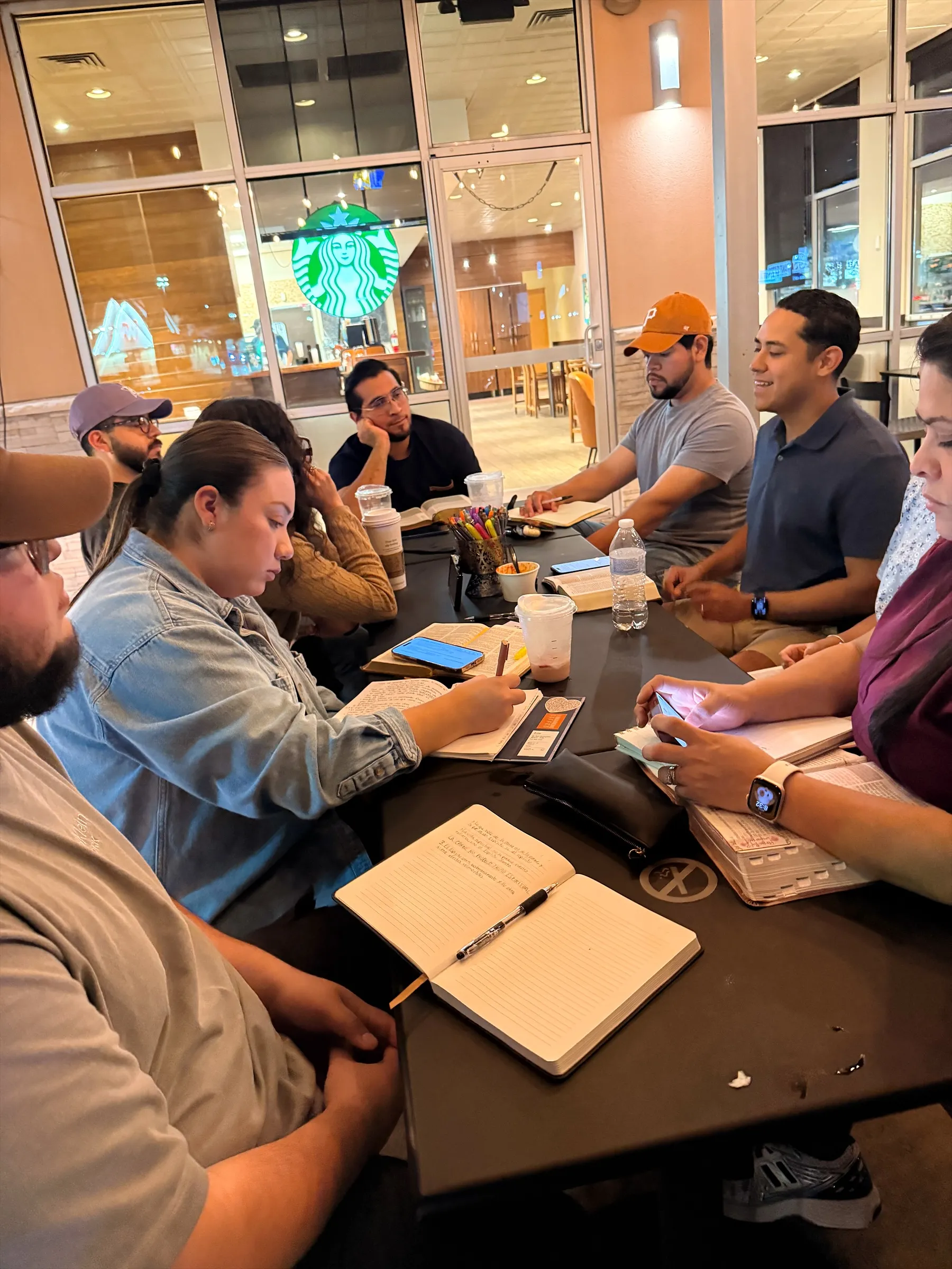 Grupo de estudio bíblico con Biblias y libretas abiertas sobre la mesa